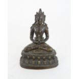 A CHINESE BRONZE MODEL OF BUDDHA seated and wearing a high jewelled crown and holding a vessel,