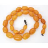 A STRING OF AMBER BEADS largest bead approx 23.2mm x 17.3mm, to smallest 13.5mm x 9.7mm, length