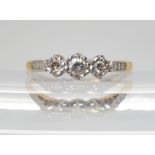 An 18ct and platinum three stone diamond ring, set with estimated approx 0.15cts of diamonds, finger