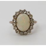 A yellow and white metal opal and clear gem set ring, size P, weight 3.1gms Condition Report: