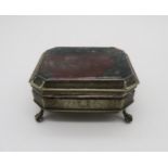 A brass and agate box, of faceted form, the body with engraved scrolling foliate decoration, on four