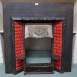 A Victorian Arts & Crafts cast iron fire insert with red tiled sides over cast iron grill, 107cm