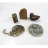 A Chinese hardstone pendant carved with fighting tigers, a disc pendant, a wooden netsuke of a
