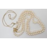 A double string of white cultured pearls with a 14k gold clasp, together with a 9ct gold neck