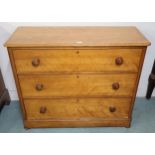 A Victorian pine three drawer chest with turned handles on bun feet, 92cm high x 111cm wide x 45cm