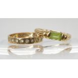A 9ct gold peridot set ring, size N1/2, and a 9ct gold clear gem set eternity ring, size M1/2,