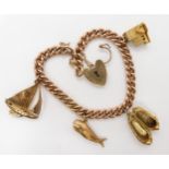 A 9ct gold curb chain bracelet, with heart shaped clasp and four 9ct gold charms to include Jonah