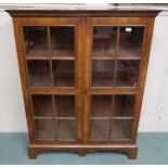 An early 20th century mahogany glazed two door bookcase, 138cm high x 107cm wide x 37cm deep