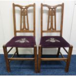 A pair of early 20th century oak Arts & Crafts chairs with stylized fretwork splats on square
