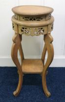 A 20th century Oriental hardwood two tier jardinière stand with carved fretwork friezes, 76cm high