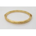 An Italian made 9ct gold bangle, inner diameters 6cm x 4.9cm, weight 7.1gms Condition Report: