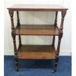 A Victorian mahogany three tier what-not with turned uprights on brass casters, 111cm high x 76cm