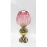 An oil lamp with cranberry glass shade Condition Report:Available upon request