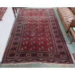 A large red ground Bokhara rug with all over lozenge design, 370cm long x 232cm wide Condition