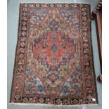 A beige ground Hamadan rug with red central medallion, blue spandrels and dark borders, 193cm long x