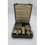 A cased silver three piece dressing set, comprising a hand mirror, clothes brush and hair brush, the