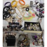 A large collection of fashion jewellery to include brightly coloured statement necklaces and bangles