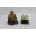 A Chinese hardstone monkey and baby on wooden stand and another of a shishi on stand Condition
