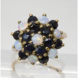 A 9ct gold sapphire and opal cluster ring 16.6mm approx diameter, fingersize L1/2, weight 4gms