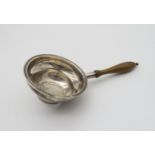 **WITHDRAWN** A George III silver tea strainer, makers mark WS, with a turned wooden handle, London