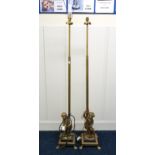 A pair of 20th century brass based standard lamps with stylized cherub bases on paw feet, 142cm high