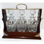 A PB & S three bottle decanter tantalus with four silver spirit labels Condition Report:Available