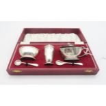 A cased silver condiment set, comprising salt, sugar bowl and preserve pot with blue glass liners, &