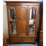 A Victorian mahogany wardrobe with inlaid central door flanked by mirror doors above two drawers,
