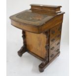 A Victorian walnut Davenport writing desk with stationary compartment above hinged writing slope and