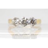 AN 18CT GOLD THREE STONE DIAMOND RING set throughout in yellow gold. The three diamonds together are