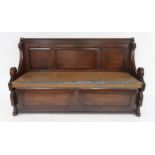 A LATE VICTORIAN OAK GOTHIC STYLE SETTLE with panelled back above Rexine upholstered seat with