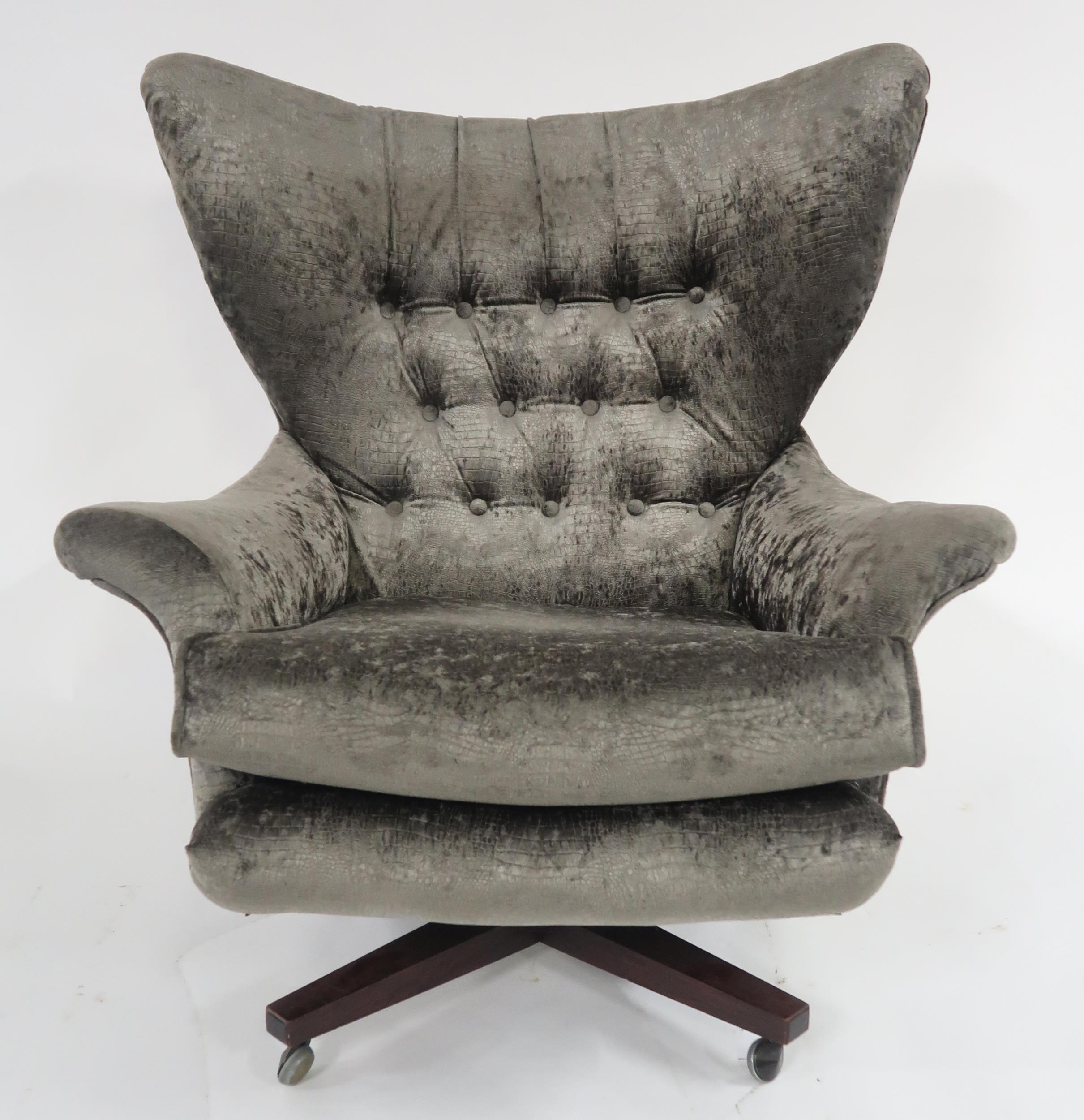 A MID 20TH CENTURY G PLAN MODEL 6250 SWIVEL WING BACK ARMCHAIR upholstered in a grey textured velour