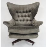 A MID 20TH CENTURY G PLAN MODEL 6250 SWIVEL WING BACK ARMCHAIR upholstered in a grey textured velour
