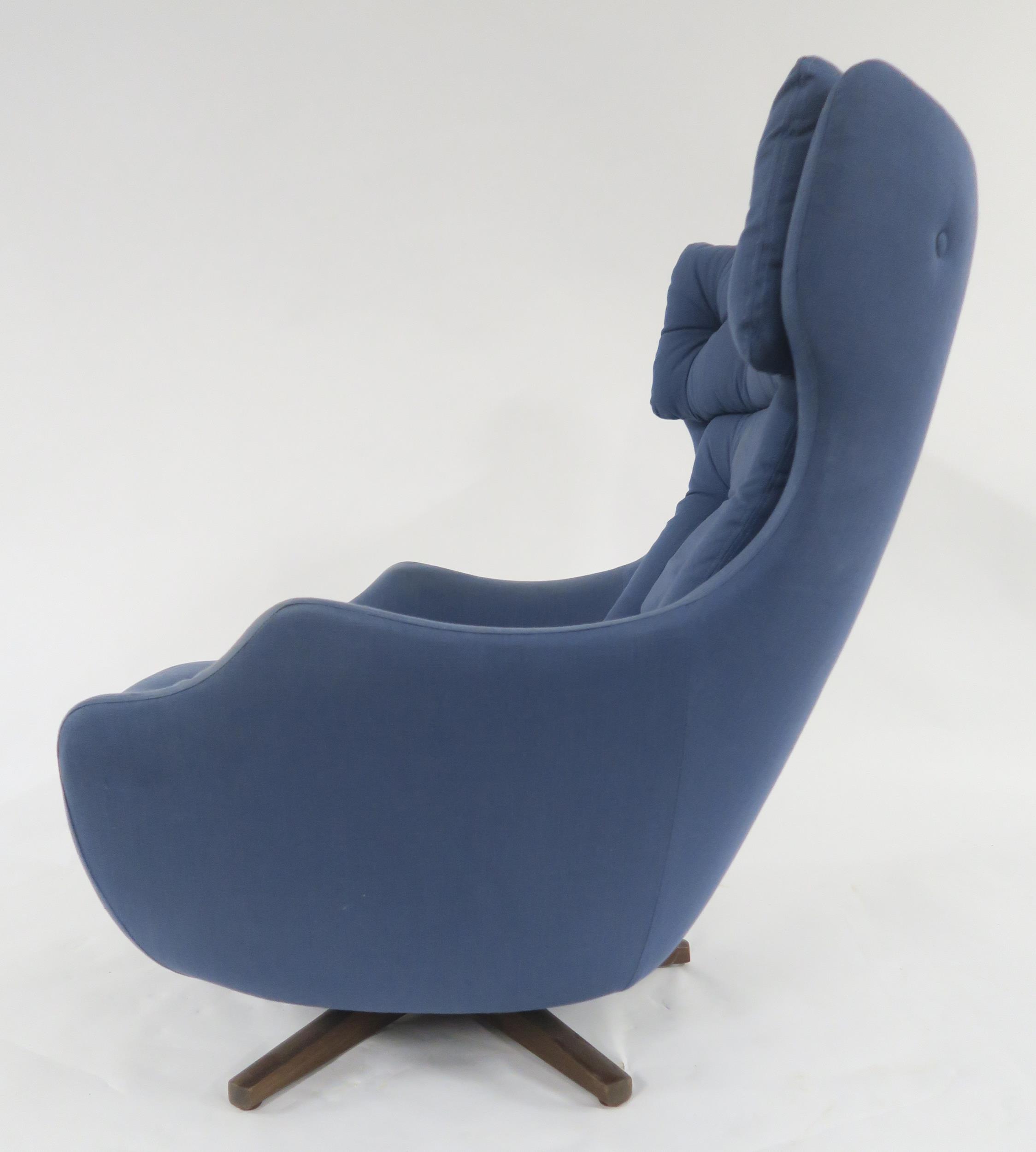 A MID 20TH CENTURY PARKER KNOLL "STATESMAN" SWIVEL ARMCHAIR with blue buttoned upholstery on stained - Image 3 of 8