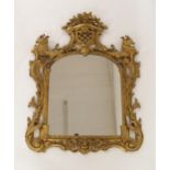 A 19TH CENTURY GILTWOOD ROCOCO MIRROR with scrolled foliate surround surmounted by flowers