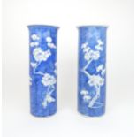 A PAIR OF CHINESE BLUE AND WHITE SPILL VASES painted with blossoming branches on a blue wash ground,