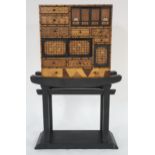 A 19TH CENTURY JAPANESE MEIJI PERIOD PARQUETRY TABLE CABINET ON A LATER EBONISED BASE, 116cm high