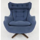 A MID 20TH CENTURY PARKER KNOLL "STATESMAN" SWIVEL ARMCHAIR with blue buttoned upholstery on stained