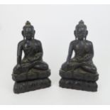 A PAIR OF ASIAN HARDWOOD CARVINGS OF BUDDHA each seated on a lotus base, 31cm high Condition