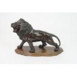 *WITHDRAWN* A JAPANESE BRONZE MODEL OF A LION naturalistically modelled, on a carved wooden base, si