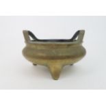 A CHINESE BRONZE TRIPOD CENSER with raised loop handles and seal mark, 15.5cm high and 22cm diameter
