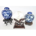 CHINESE HARDWOOD STAND AND SHELL 25cm high, and two blue and white jars and covers,