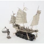 A WHITE SILVER MODEL OF A JUNK mounted on a carved wood wave base
