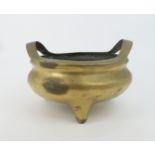 A CHINESE BRONZE TRIPOD CENSER with raised loop handles and dragon seal mark, 19cm high and 28cm