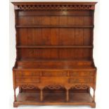 A 20TH CENTURY STAINED OAK WELSH STYLE DRESSER with corniced plate rack top above five short