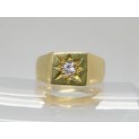AN 18CT GOLD GENTS SIGNET RING set with a 0.20ct brilliant cut diamond in star burst setting.