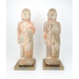 A PAIR OF PAINTED RED POTTERY FIGURES OF SOLDIERS modelled standing to attention with fierce