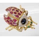 A RUBY, SAPPHIRE, & DIAMOND BEETLE BROOCH with emerald eyes. With articulated legs, head and wing