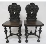 A PAIR OF VICTORIAN OAK HALL CHAIRS with carved backs depicting lions rampant flanking central