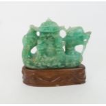 A CHINESE GREEN FLUORSPAR LAMP CARVING carved as a dragon boat, seated on a carved hardwood base,